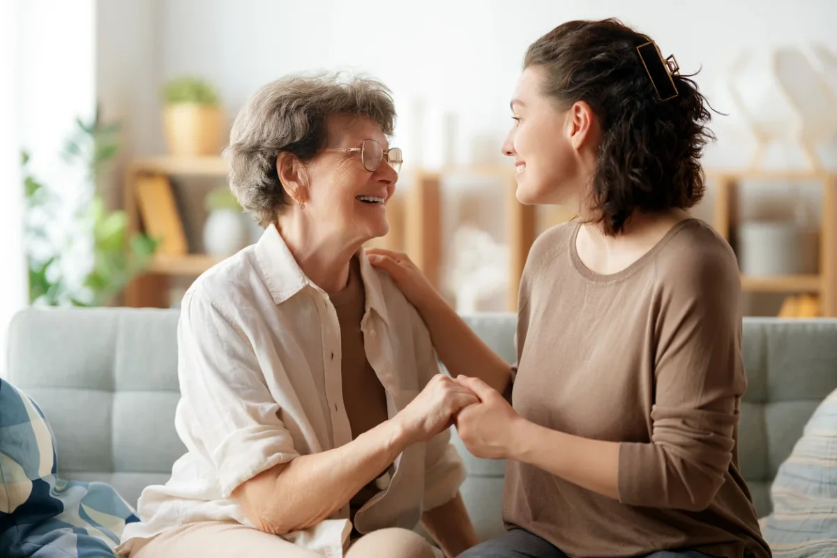 long-distance caregiving tips shown through an older adult sharing a supportive moment with a younger family member at home.