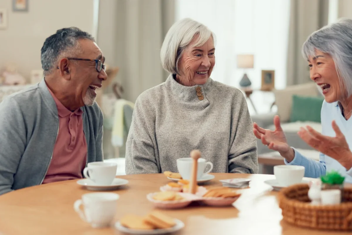 Skilled Nursing vs Assisted Living shown through older adults socializing together in a comfortable senior living setting.